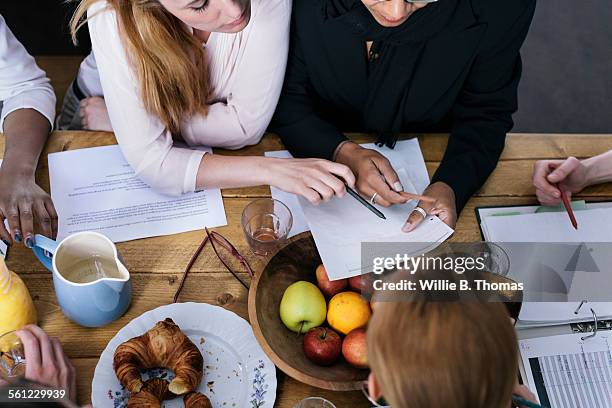 women around table having a business meeting - breakfast meeting stock pictures, royalty-free photos & images