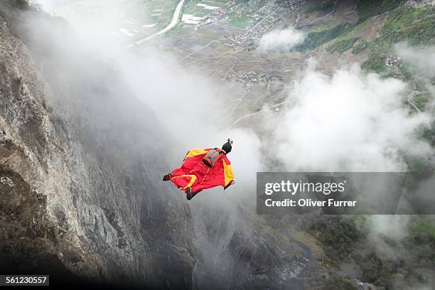 wingsuit proximity flyer is diving down the cliff - deporte de riesgo fotografías e imágenes de stock