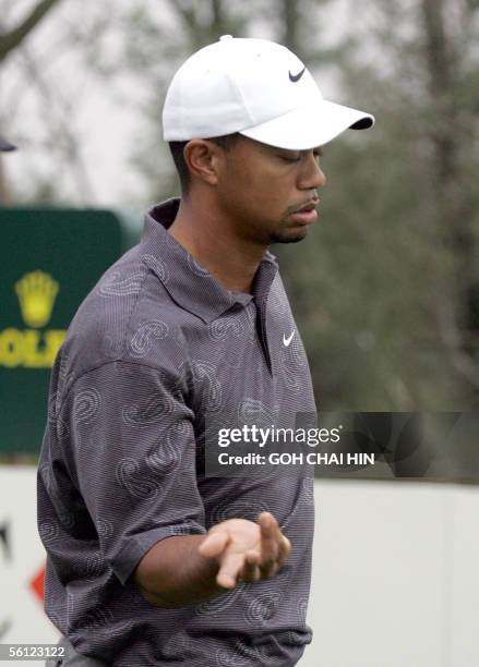 World number one Tiger Woods gestures with his wrist after teeing off during a practice round at the five-million-dollar HSBC Champions tournament in...