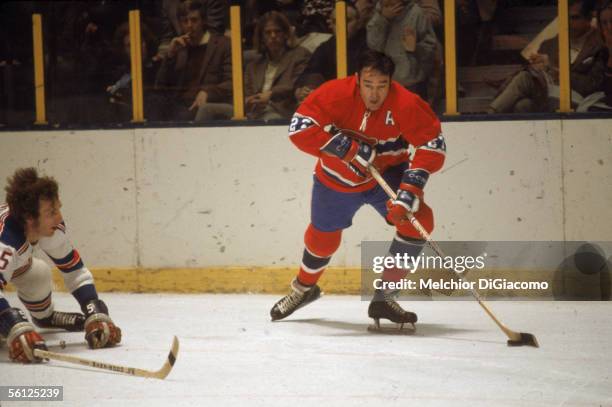 Canadian professional hockey player Frank Mahovlich of the Montreal Canadiens controls the puck on the ice as an opponent defends during a road game...