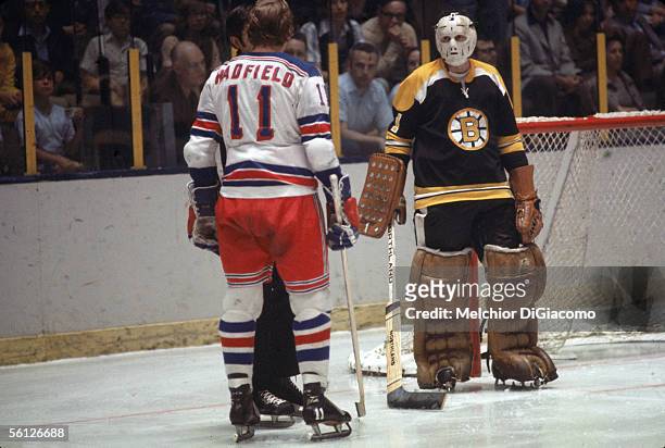 Canadian hockey player Ed Johnston, goalie of the Boston Bruins, looks on as Ranger Vic Hadfield has words with the referee during a game against the...