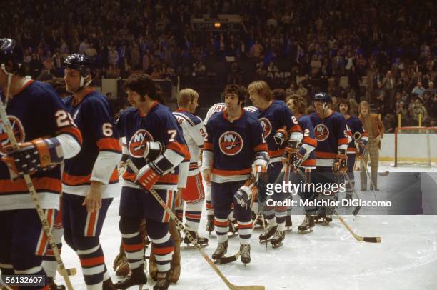 Canadian pro hockey player J.P. Parise and his New York Islanders shake hands with their rivals the New York Rangers after his overtime goal won the...