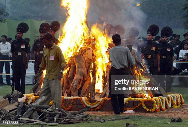 Indian Army officers stand in respect in front of former Indian President Kocheril Raman Narayanan's funeral pyre in New Delhi, 10 November 2005....