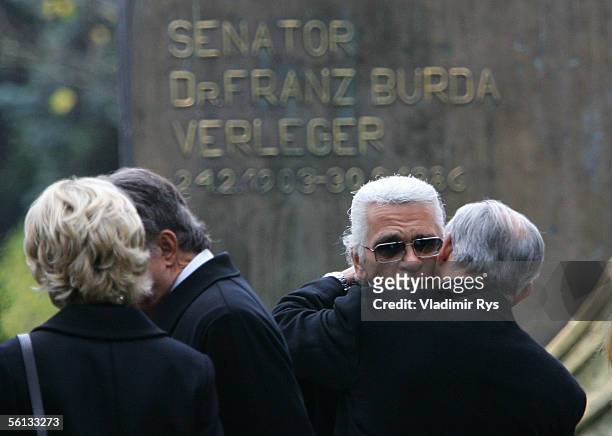Hubert Burda hugs Karl Lagerfeld next to the grave of his mother Aenne Burda after her funeral service on November 10, 2005 in Offenburg, Germany....