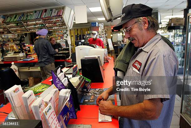 Lotto player Gary Hoerth from Fond Du Lac, Wisconsin picks numbers in the Mega Millions lottery at a gas station which is located on the border of...