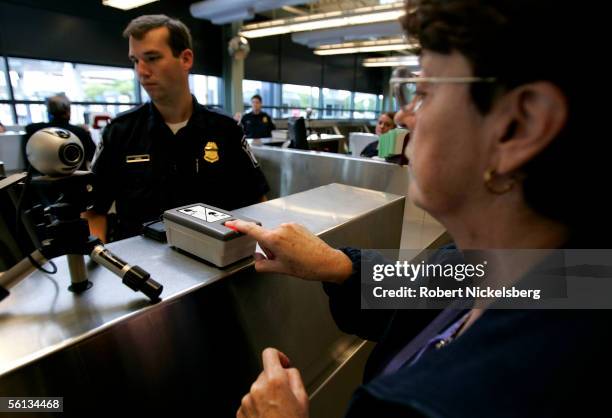 Customs and Border Protection officer checks the passport of a European tourist on the Rainbow Bridge in on September 20, 2005 in Niagara Falls,...