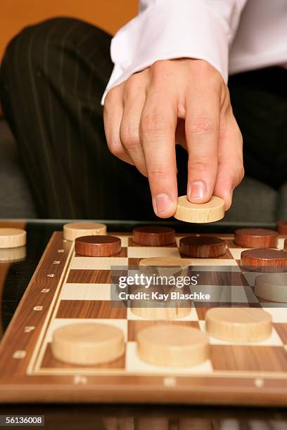 businessman playing checkers, focus on hand - checkers game ストックフォトと画像