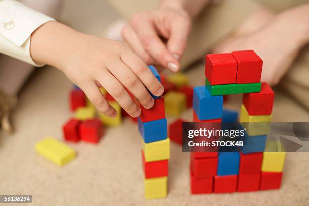 girl and woman stacking blocks, focus on hands - wood block stacking stock pictures, royalty-free photos & images