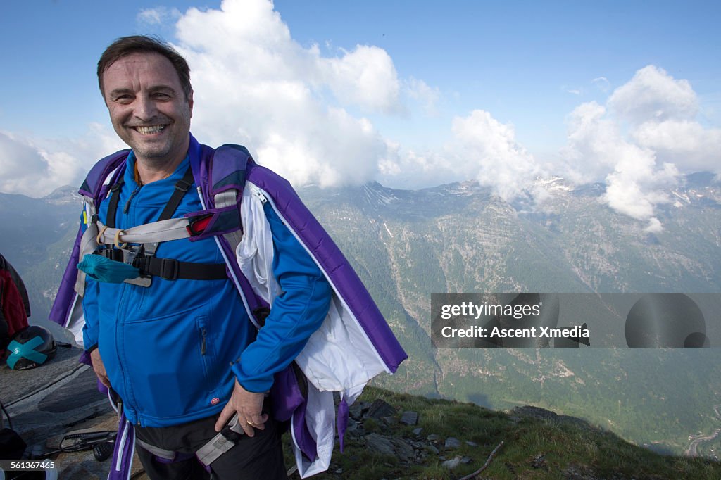 Portrait of older wingsuit flier, mountain summit