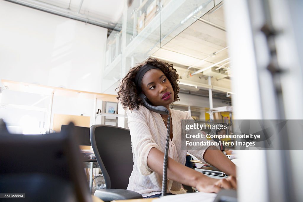 Businesswoman using phone while working in office