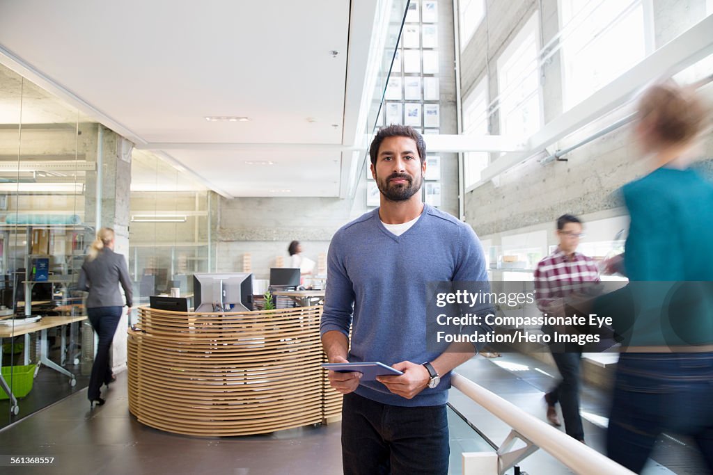 Portrait of businessman in busy lobby