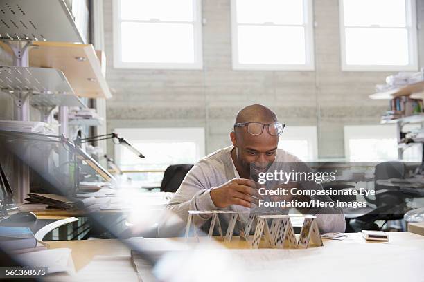 businessman making house of cards in office - house of cards stock pictures, royalty-free photos & images
