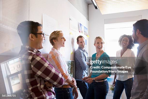 business people laughing in meeting - happy group photos et images de collection