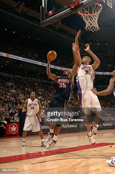 Jason Collins of the New Jersey Nets goes to the basket against Loren Woods of the Toronto Raptors during the game at Air Canada Centre on November...