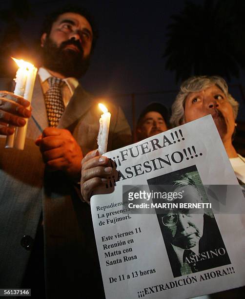 Personas protestan pacificamente mostrando un afiche alusivo al ex presidente peruano Alberto Fujimori durante un protesta de activistas de DDHH y...
