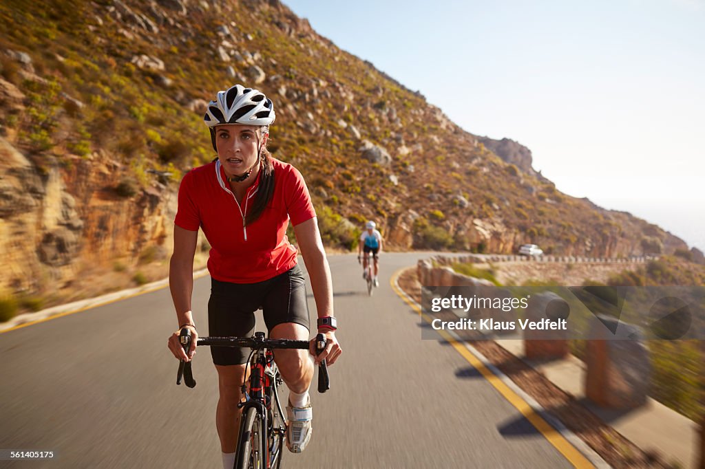 Female pro cyclist taking lead on mountain climb