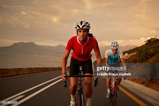 bike rider accelerating from training partner - anführen stock-fotos und bilder