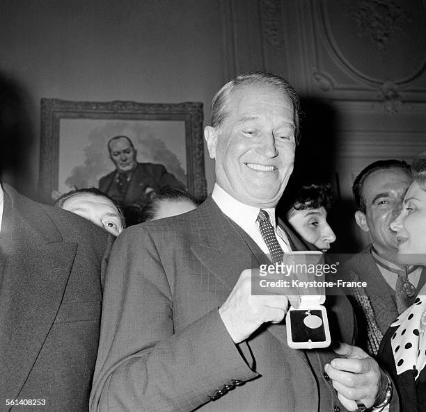 Le chanteur Maurice Chevalier pose avec la médaille de 'Meilleur artisan de la chanson française' qui vient de lui être décernée dans les salons de...
