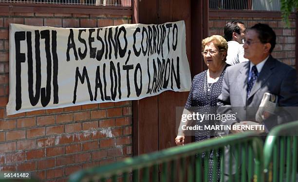 Una pareja pasa frente a un afiche alusivo al ex presidente peruano Alberto Fujimori , frente a la Escuela de Gendarmeria en Santiago el 11 de...