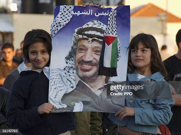 In this handout image supplied by the Palestinian Press Office , two girls hold a picture of Yasser Arafat during a commemoration ceremony for the...