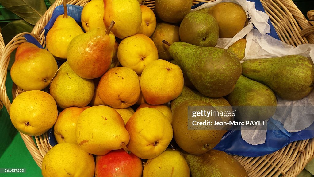 Assorted green and yellow pears in a wicker basket