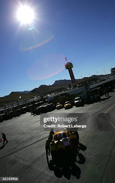 The crew of the Roush Racing DeWalt Power Tools Ford, driven by Matt Kenseth, push his car back into the garage area during practice for the NASCAR...