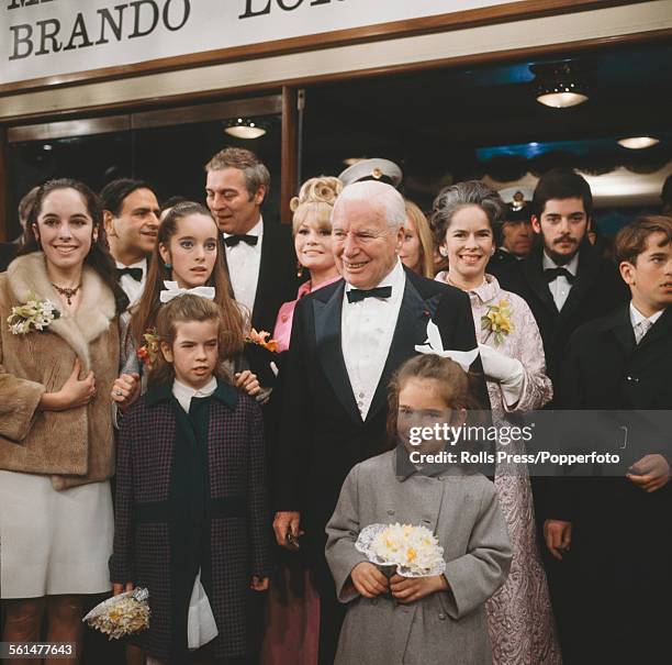 English actor Charlie Chaplin pictured centre with members of his family at the premiere of the film 'A Countess from Hong Kong' at the Carlton...