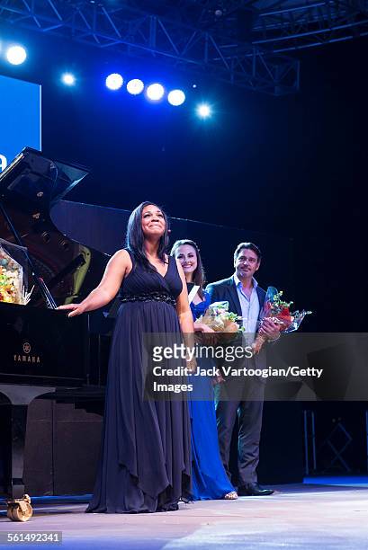 View of American soprano Janai Brugger , joined by mezzo-soprano Isabel Leonard and baritone Nathan Gunn, onstage during an encore at the seventh...