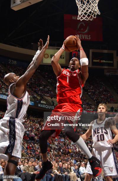 Tracy McGrady of the Houston Rockets shoots against Marc Jackson of the New Jersey Nets at the Continental Airlines Arena on November 12, 2005 in...