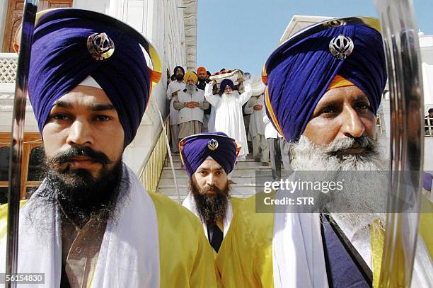 Indian Sikh devotees walk ahead of the Guru Granth Sahib, the holy book of the Sikh religion, in a procession at the Golden Temple in Amritsar, 14...