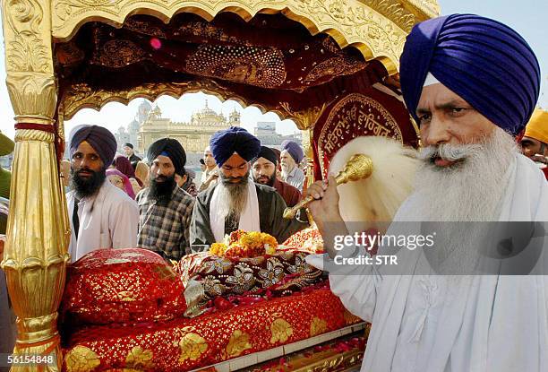 Indian Sikh priests walks beside the Guru Granth Sahib, the holy book of the Sikh religion, in a procession at the Golden Temple in Amritsar, 14...