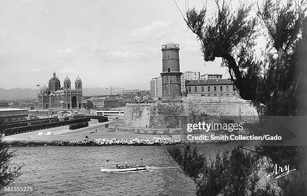 The cathedral basilica of Notre-Dame-de-la-Gardeand the fort Saint Jean in the port, Marseille, Cote d'Azur, France, 1930.