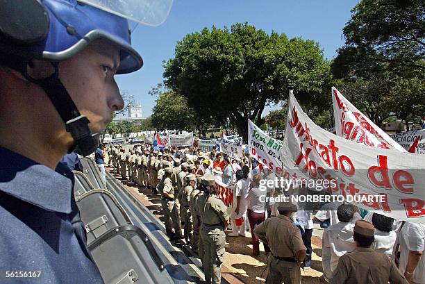 Medicos de hospitales publicos son custodiados por policias cuando se manifiestan frente al Congreso Nacional el 14 de noviembre de 2005 en Asuncion,...