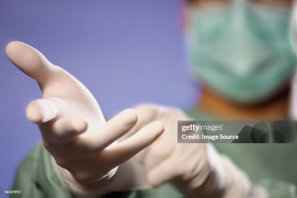 Surgeon putting on gloves