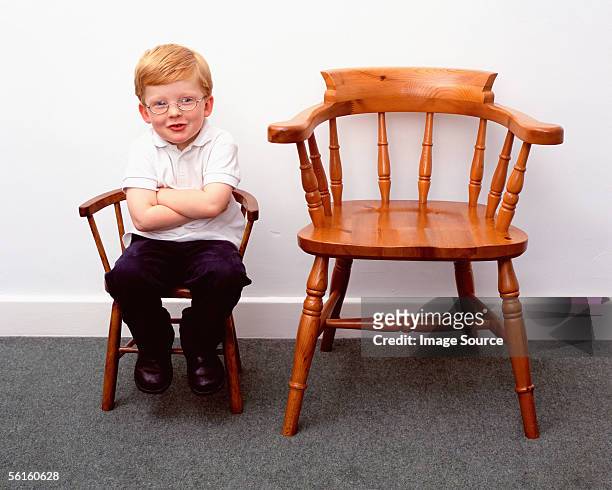 boy and little and large chairs - kid in big shoes stock pictures, royalty-free photos & images