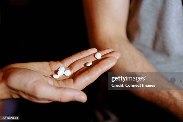 male hand holding recreational drugs - amphetamine photos et images de collection