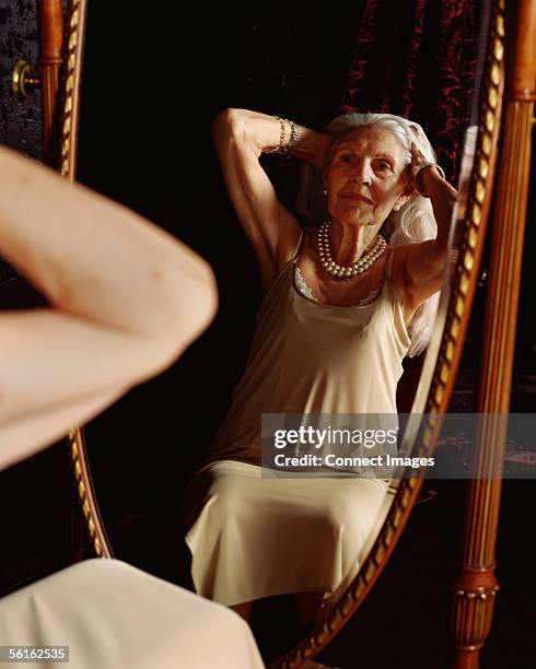 senior woman looking in the mirror - old lady nightgown stock pictures, royalty-free photos & images