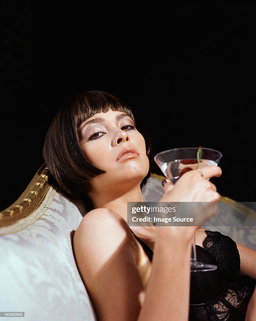 Glamourous young woman drinking a cocktail