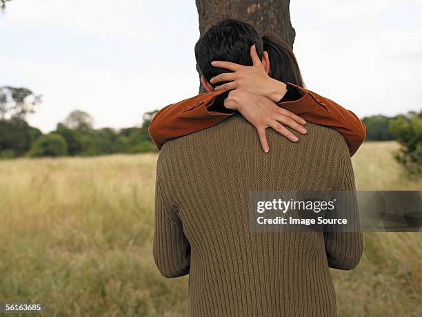couple kissing against tree - beso en la boca fotografías e imágenes de stock