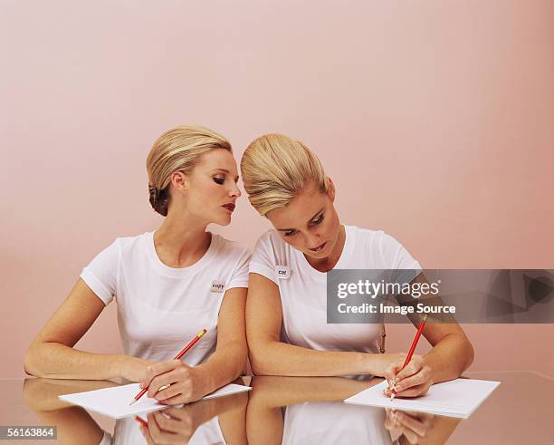 woman copying another's work - identical twin stock pictures, royalty-free photos & images