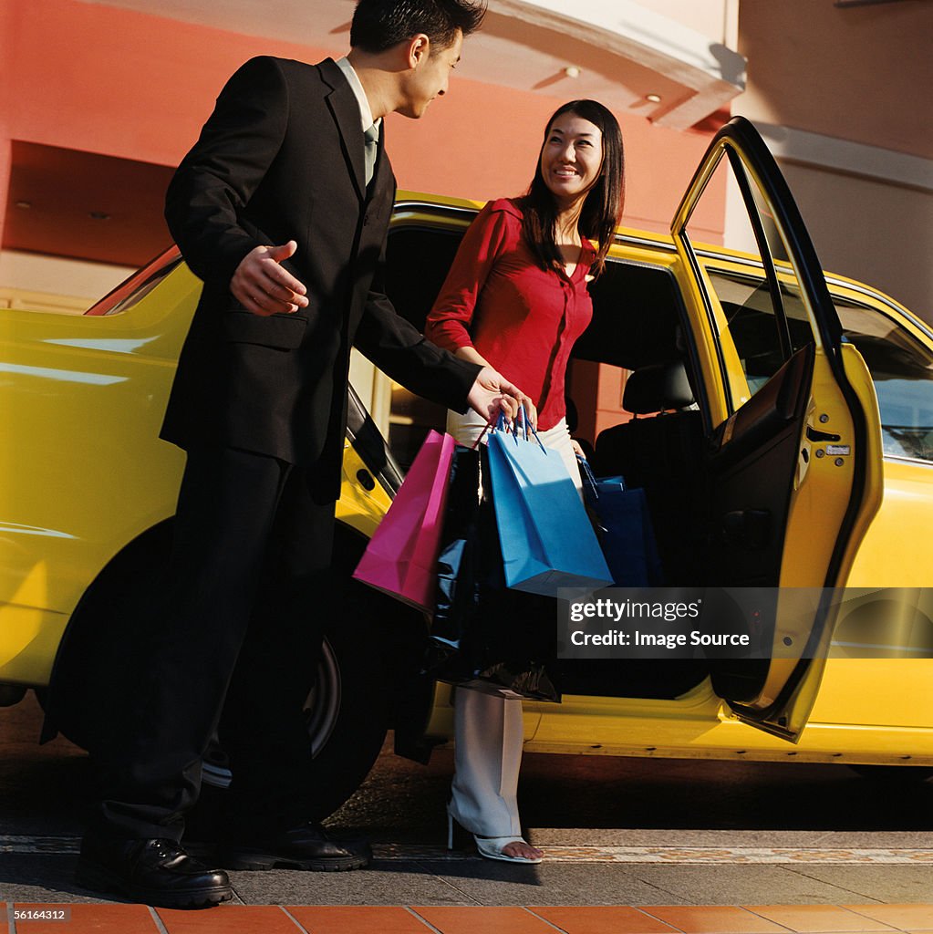 Young couple leaving taxicab