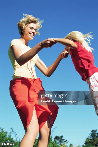 mother and daughter jumping - trampoline jump stock pictures, royalty-free photos & images