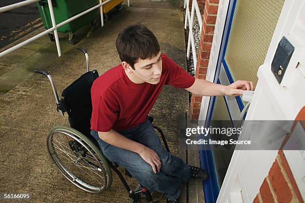 disabled man opening front door - rolstoelvriendelijk stockfoto's en -beelden