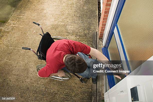 disabled man opening front door - wheelchair access stock pictures, royalty-free photos & images