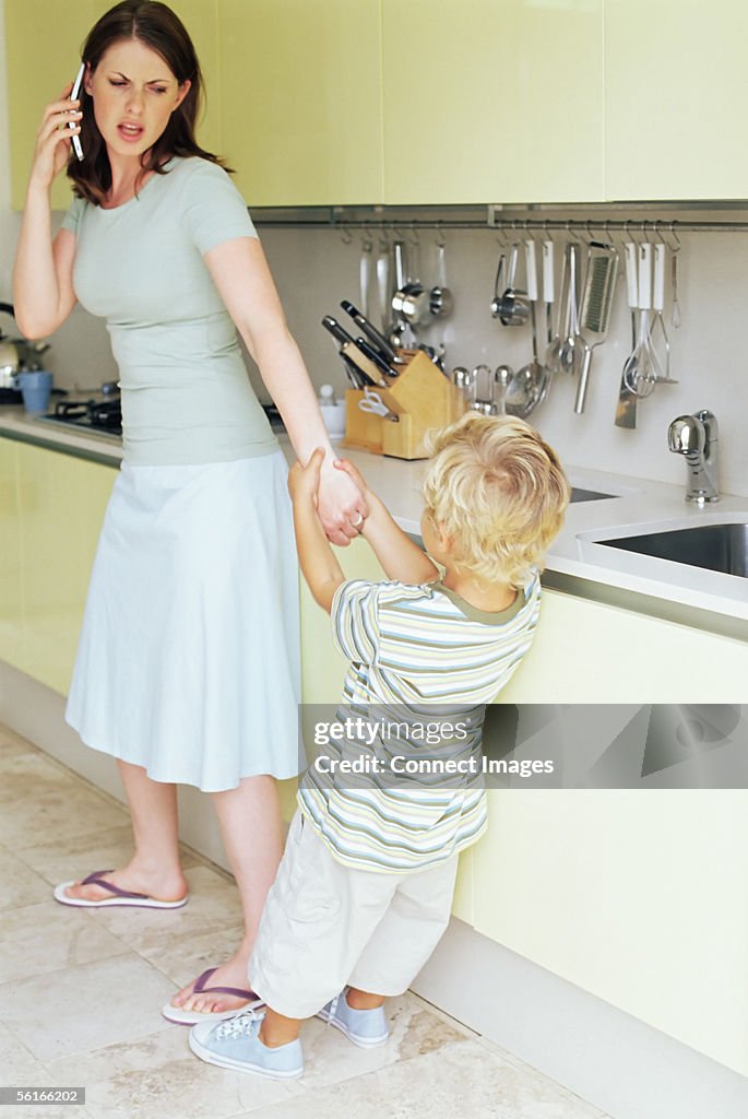 Boy pulling on mother's arm