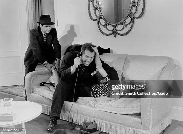 Mayo Methot, subdued on a couch by Ward Bond during filming of the movie 'Numbered Woman,' 1938.