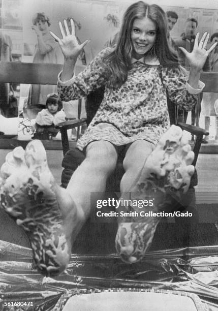 Actress Samantha Eggar makes impressions of her footprints in the foyer of a London theater, August 11, 1966.