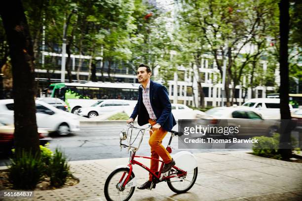Businessman riding bike on city sidewalk