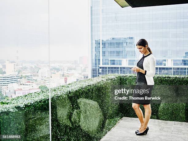 female business executive looking at smartphone - frau business glas modern stock-fotos und bilder