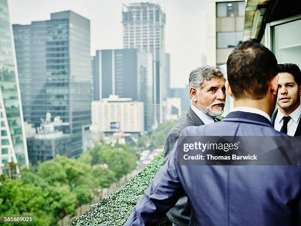 business executives on terrace overlooking city - mexico city architecture stock pictures, royalty-free photos & images